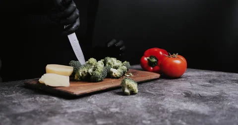 Cuts broccoli on black kitchen table before cooking salad breakfast Stock Footage 148244901