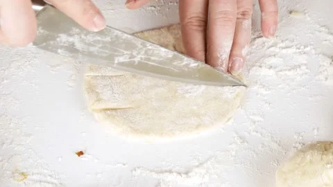 Cuts the dough with a large kitchen knife.Prepares a cutlet in dough. Stock-Footage 147314987