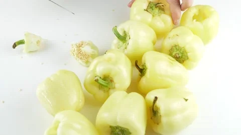 Cuts with a knife the core of the pepper.A bunch of yellow peppers on the table. Stock Footage 136895085