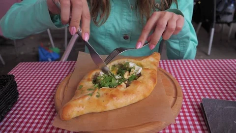 Cuts with a knife with a fork khachapuri in restaurant closeup. Stock-Footage 77315251