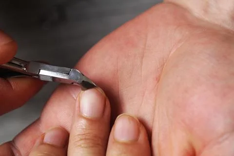 Cuts nails with clippers scissors close-up Stock Photos