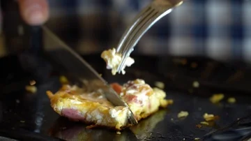 Cuts an omelet with a knife Stock Footage 86160045
