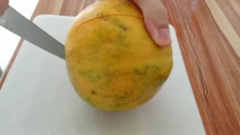 Cuts the papaya into two pieces Stock Footage 328991667