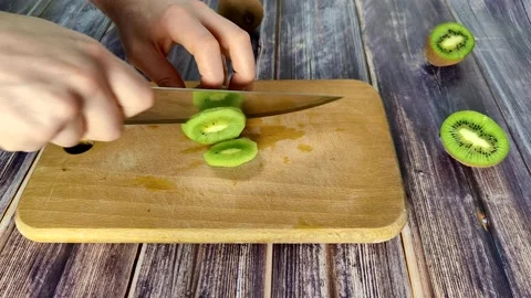 Cuts the peeled kiwi into segments Stock Footage 227722231