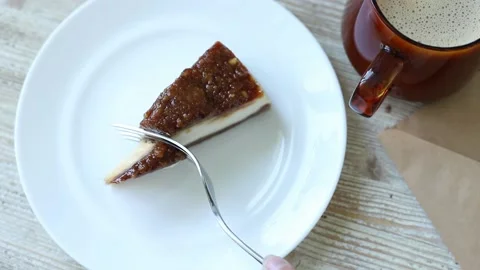 Cuts off a piece of cheesecake with a fork eating Stock Footage 163159957