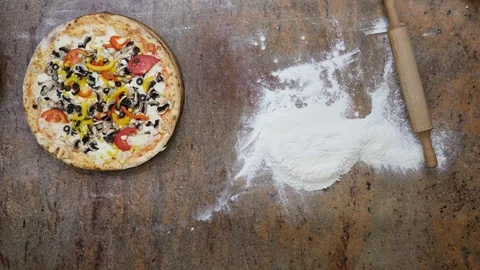 Cuts the pizza on a dark background in the kitchen Stock Footage 77168030