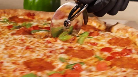 Cuts a pizza with a knife Stock Footage 260866991