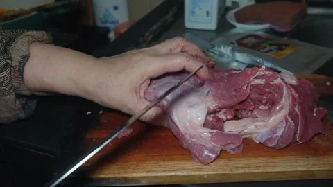 Cuts raw beef into pieces with a sharp knife Stock Footage 310825784