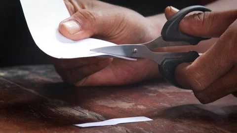Cuts a sheet of white paper Stock Footage 335862606