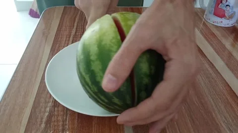 Cuts a small watermelon into two pieces Stock Footage 327232878