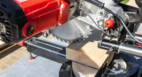 Cuts a wooden beam using a circular saw. Home furniture workshop. Work in his Stock Photos