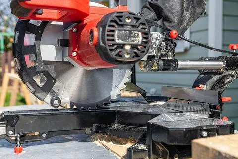 Cuts a wooden beam using a circular saw. Home furniture workshop. Work in his Stock Photos