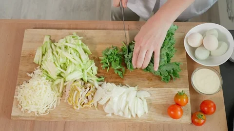 Cuts young cabbage kale leaves with a sharp knife on a wooden board, greens Stock Footage 270151396