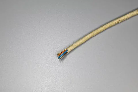 Cutted beige network cable, damaged wire on grey background Stock Photos