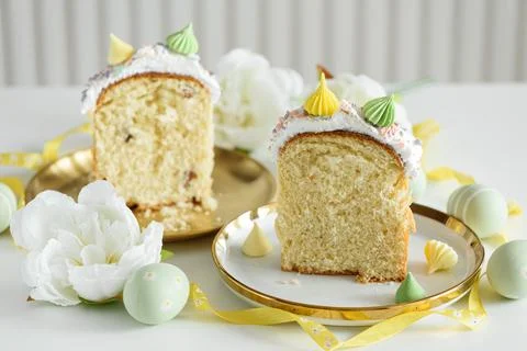 Cutted Easter Cake Decorated Yellow Ribbon with Flowers and Pastel Eggs on .. Stock Photos