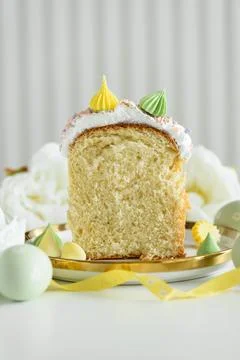 Cutted Easter Cake Decorated Yellow Ribbon with Flowers and Pastel Eggs on .. Stock Photos