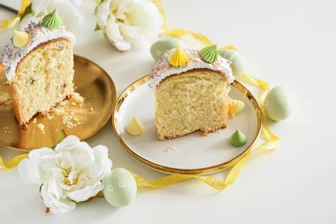 Cutted Easter Cake with Flowers and Pastel Eggs on White Background Stock Photos