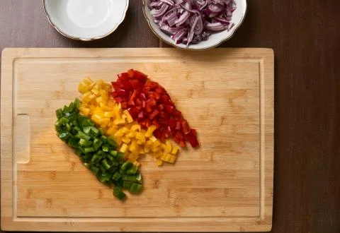 Cutted fresh paprika pieces top down view on a bamboo cutting board with cutted Stock Photos