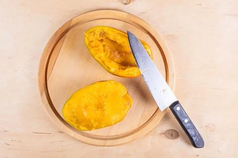 Cutted in halves mango on woden table Stock Photos