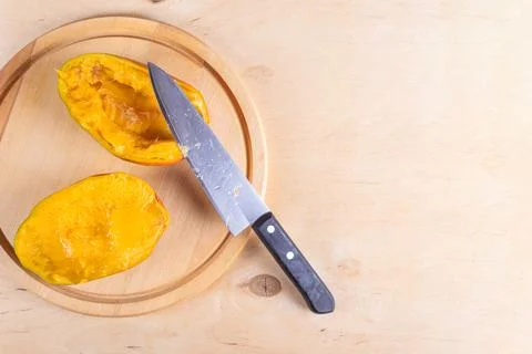 Cutted in halves mango on woden table Stock Photos