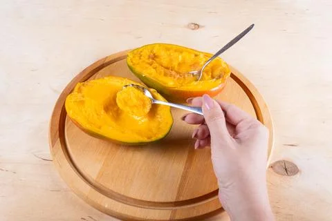 Cutted in halves mango on woden table Stock Photos