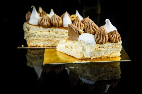 Cutted piece of delicious double layer Kiev cake abundantly decorated with ch Фото