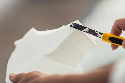 Cutter shaping a piece of polystyrene in a workshop Stock Photos