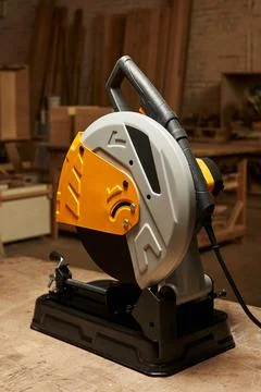Cutting abrasive disc machine for cutting hard materials stands on a wooden Stock Photos