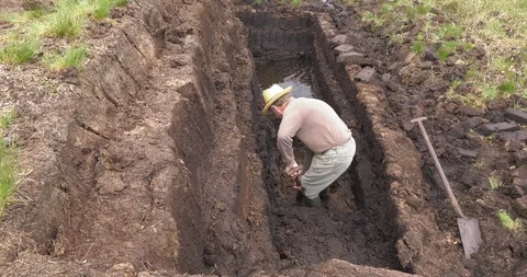 Cutting and Fitting Turf Peat with a spade in a Bog in Ireland Stock Footage 101842085