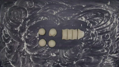 Cutting and rolling raw dough on wooden table, timelapse, handmade cooking Video stock 221439059