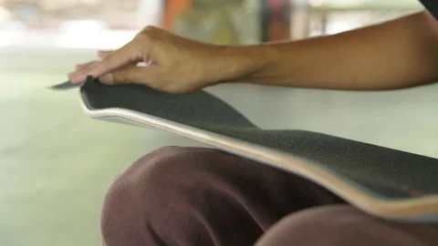 Cutting and sanding excess grip tape on skateboard 動画素材 321473939