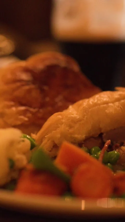 Cutting and Serving Steak Pie with Vegetables in Cozy Restaurant Stock Footage 317591406