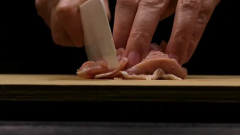 Cutting and slicing chicken fillets as part of the homemade recipe or preparatio Stock Footage 107510253