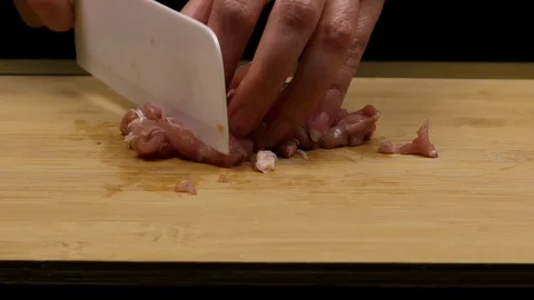 Cutting and slicing chicken fillets as part of the homemade recipe or preparatio Stock Footage 107510302