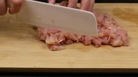 Cutting and slicing chicken fillets as part of the homemade recipe or preparatio Stock Footage 107511595
