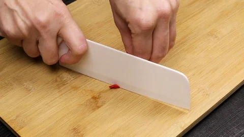 Cutting and slicing red hot chili pepper as part of the home cooking recipe. Stock Footage 107568300