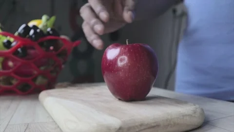 Cutting an apple with a knife. The chef cuts the apple on a cutting board. healt Stock Footage 155117328
