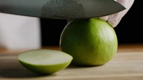 Cutting apples with chef knife macro shot Stock Footage 128490367