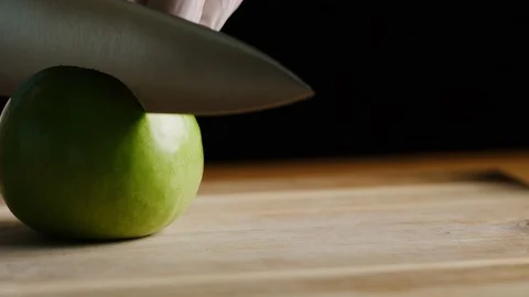 Cutting apples with chef knife macro shot Stock-Footage 128490517