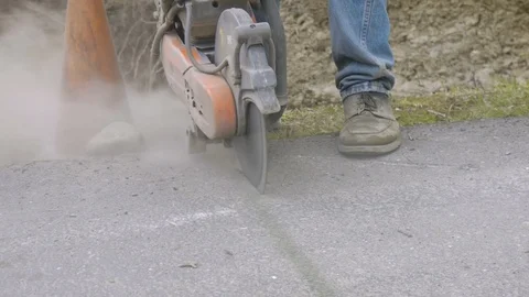 Cutting asphalt with skill saw Stock Footage 104569512