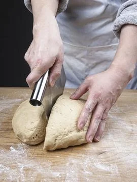 Cutting a ball of dough. Stock Photos