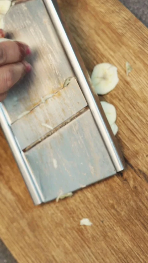 Cutting banana slice for making chips on a wooden board. Stock Footage 282567338