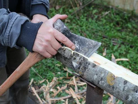 Cutting bark from a log with an ax Stock Photos