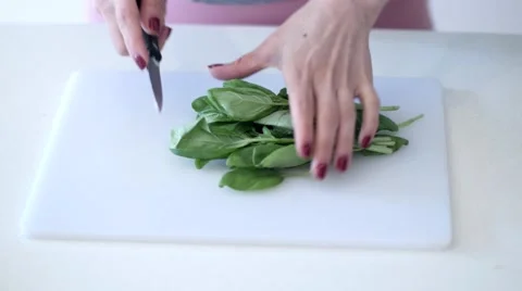 Cutting up basil on a chopping board Stock Footage 64090523