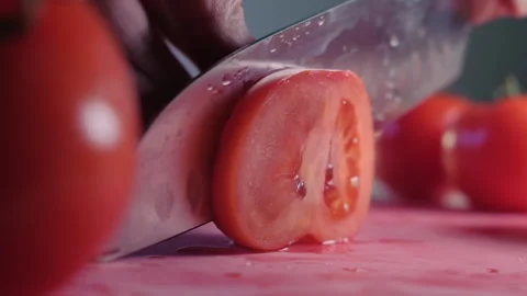 Cutting beautiful red tomato using kitchen knife, water drops macro video. Fresh Stock-Footage 154356244