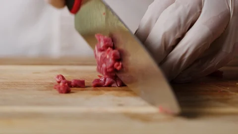 Cutting beef with chef knife macro shot, preparing ingredients for Tar Tar Stock Footage 128488105