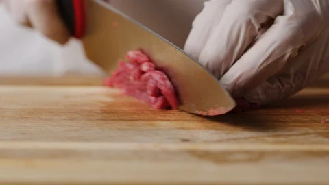 Cutting beef with chef knife macro shot, preparing ingredients for Tar Tar Stock-Footage 128488261