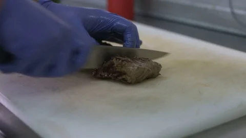 Cutting a beef stake on a white cutting board. Restaurant service Stockbeeldmateriaal 72319765