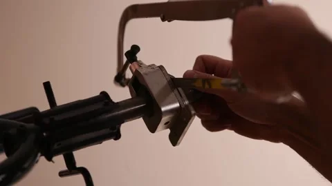 Cutting a bicycle fork metal steerer tube with a hacksaw blade close up Stock Footage 307453758