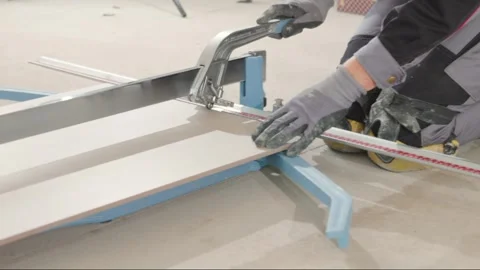 Cutting a big tile with a professional tile cutter. Equipment. Tools. Stock Footage 340010017